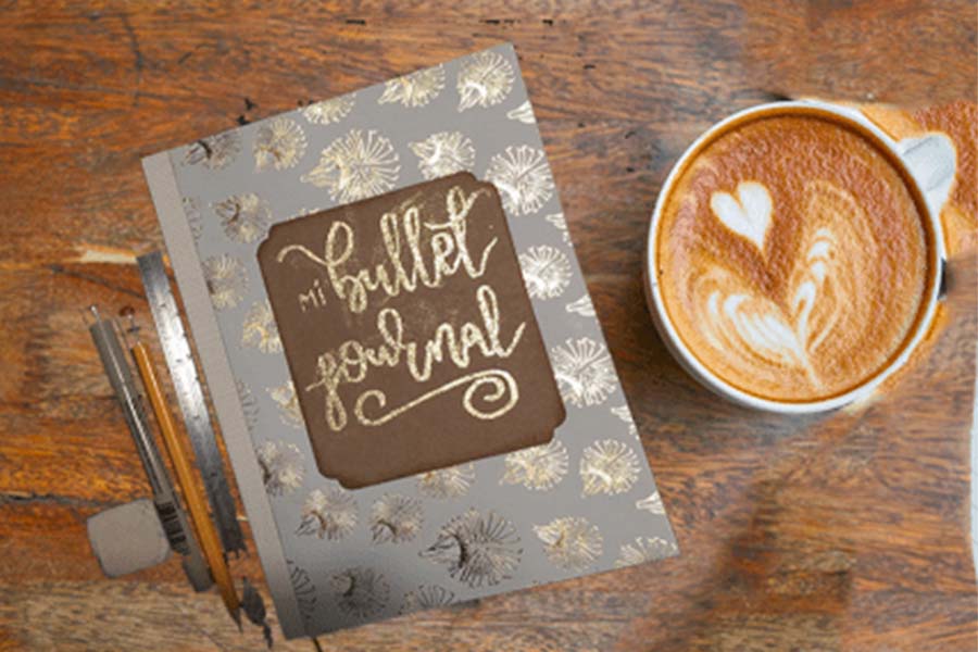 una agenda estilo bullet journal y una taza de cafe