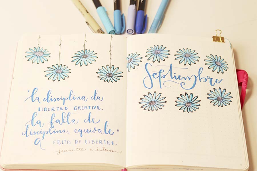 portada que dice sepiembre que va decorada con flores en tonos azules y una frase