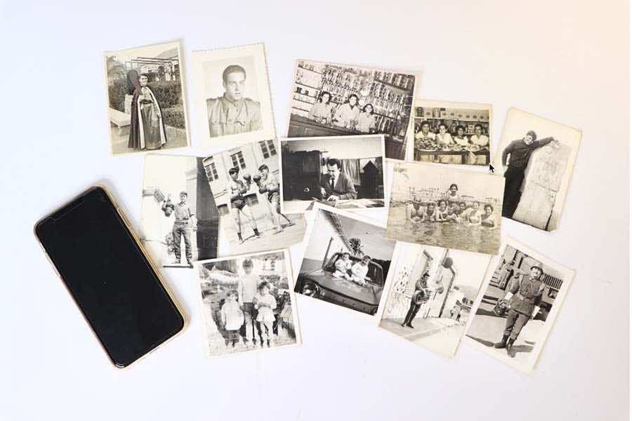 varias fotos antiguas en blanco y negro con un móvil puestos sobre una mesa.